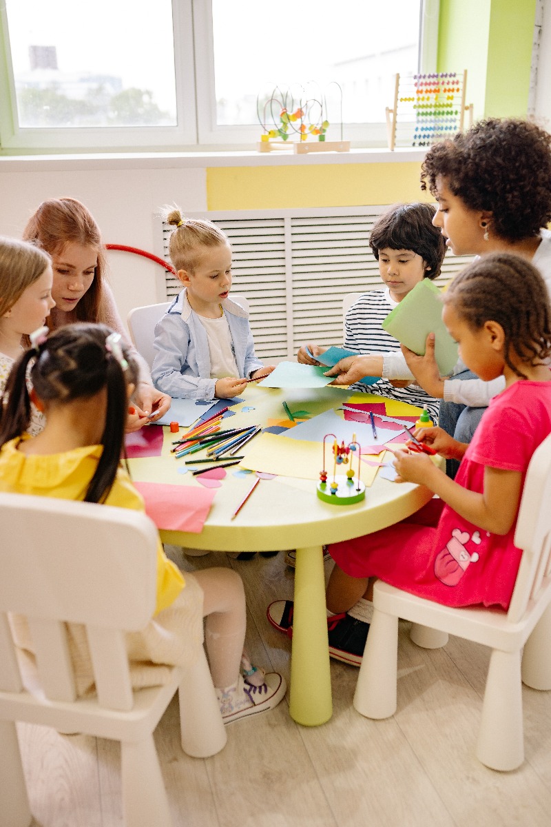 Enfants de maternelle et professeur réunis autour d’une table